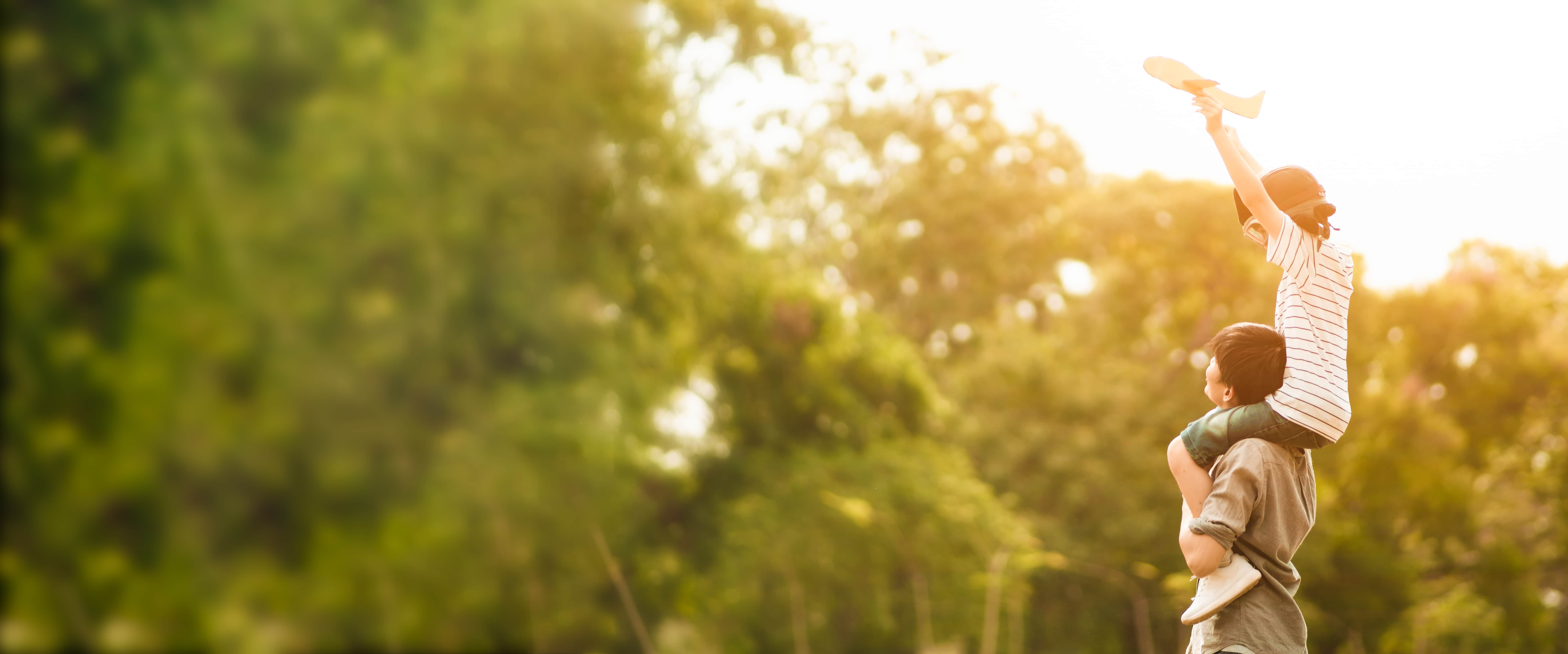 Child sitting on parents shoulders